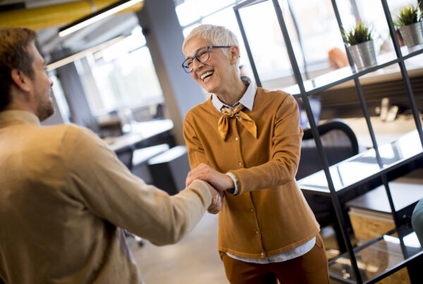 Grateful senior businesswoman boss lady hold hand of best employee